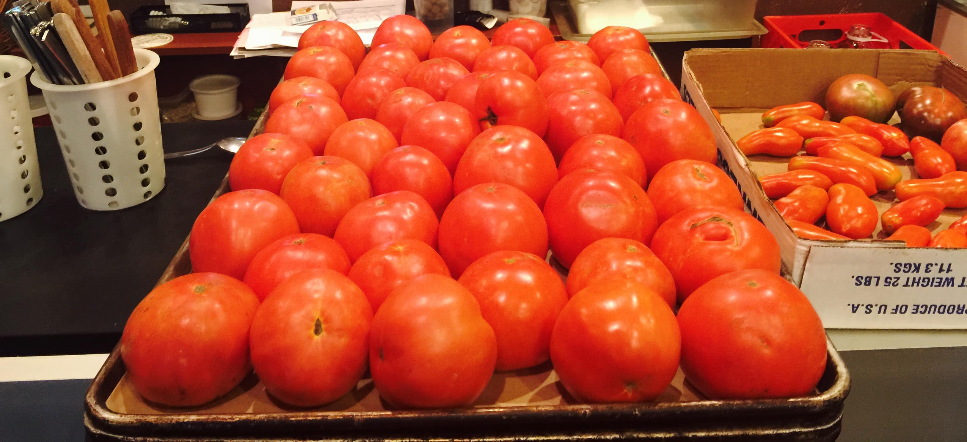 A photograph of a large tray of tomatoes.