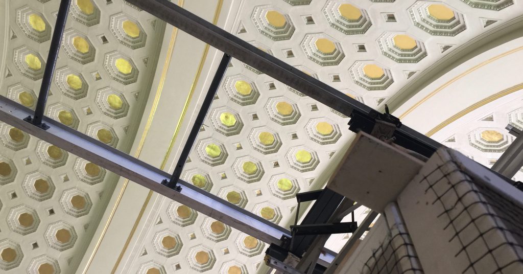 Photograph of the gold leafed ceiling of Union Station in Washington, D.C., with scaffolding in the foreground.
