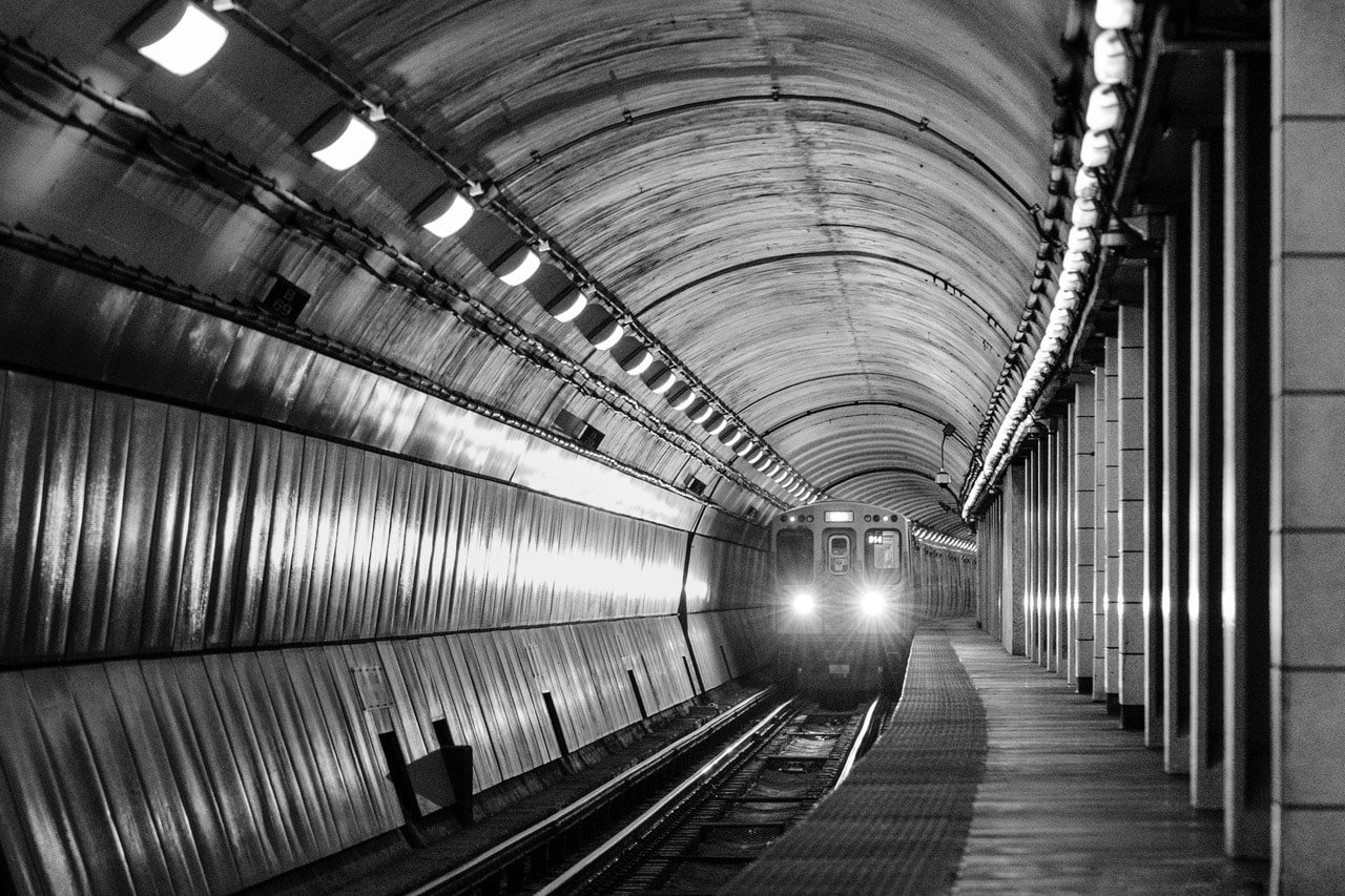 Alt Text: Black and white photograph of a subway train approaching.